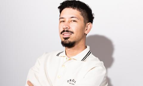 Noel Miller wears a white polo shirt while posing in front of a white backdrop.